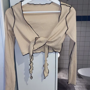 Beige topp med svarta detaljer - Beige topp att ha över ett linne tex