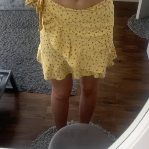 Volangkjol - En söt gul omlottkjol med volang och små blommor. Storlek S men kan passa både XS och M då man knyter den utefter midjan. Kontakta vid frågor eller annat💞