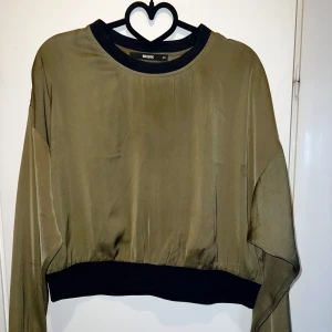 Blus - Grön flowy & glansig blus med muddar från bikbok. 