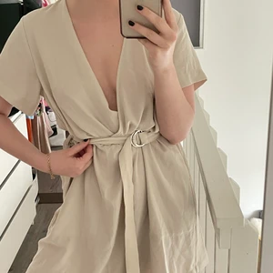 Beige klänning  - Beige super snygg klänning från weekday!! Jätte fin kvalite och sparsamt använd. Bälte i midjan som går att reglera. Passar från S-L. Sitter snyggt oversized om man är som mig (jag är en ca S/M) 