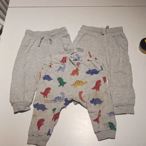 Byxor barn - 2st helfärgade grå, 1st grå med dinosariemotiv. Alla i storlek 80. Sparsamt använda.
