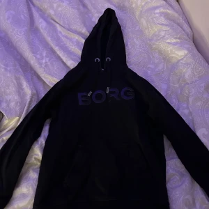 Svart huddie från Björn Borg  - Svart huddie från Björn Borg med tryck på bröstet. Knappt använd. Kan mötas upp i Skövde eller frakta. Köparen står för frakten.