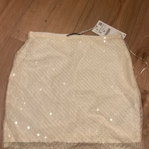 Paljettkjol - En jättesöt kjol med detaljer av paljett på. Helt oanvänd, lappen är fortfarande på. 