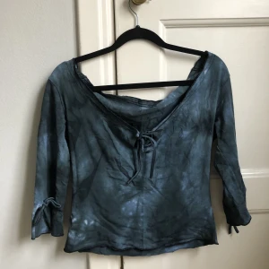 Topp med söta detaljer  - Blå stentvättad/batik topp med söta detaljer. Snörning fram vid bröstet och vid handlederna.  Köpt second hand. Frakt 40 kr😽