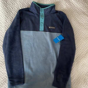 Columbia fleecetröja  - Columbia fleecetröja med knäppning  i halsen. Regular fit, storlek m. Oanvänd. 
