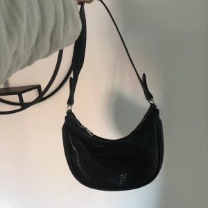 Väska med ormimitation från Nelly - Svart handväska med ormimitation från Nelly, nästan aldrig använd