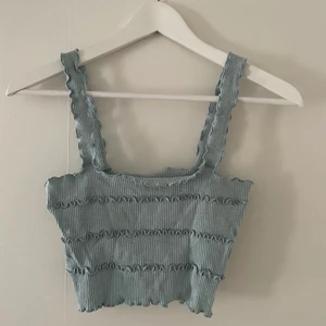 Zara topp - Topp från Zara i ljusblå med ribbat, skrynkligt material. Storlek M. Skriv för bilder med toppen på, för bättre bild av passform osv. Säljer för 50kr + frakt (frakten kan variera utöver skrivet pris).