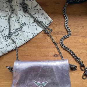 Zagdig & Voltaire väska - Liten väska, som mer är en cool accessoar. Har två kedjor till; en lång gross-body och en kortare (och grövre) till axel längd. Den har alltid varit skiftande i materialet/färg.