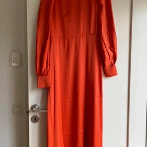 Långklänning  - Ny med lappen kvar! Öppen en bit ner i ryggen. Fina knappar, blankt  jättefint tyg! St S  bud från 150kr skickas med skicka lätt 66kr 