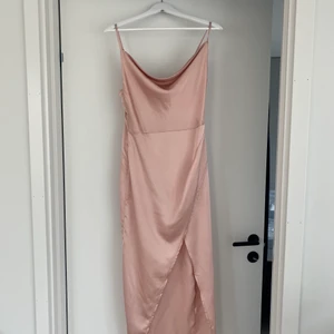 Satinklänning från Nasty Gal - Ljusrosa satinklänning med slit från Nasty Gal. Passar S. Använd 1 gång. Nypris: 800kr
