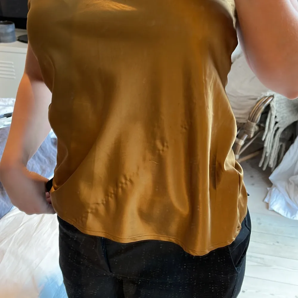 Guldigt linne från Zara med justerbara band. Basic modell. Storlek M. Gått en tråd mitt på:(. Toppar.