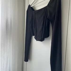 Svart topp - Snygg svart topp som formar sig snyggt efter kroppen. Endast använd en gång så är som ny!