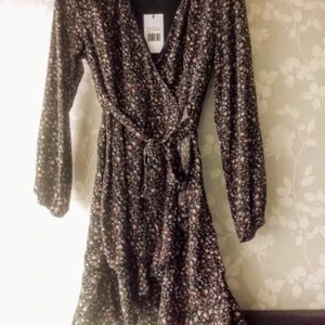 Klänning Sisters point  - Klänning Sisters Point. XL (liten i stl) Svart m rosa och blå blommor. Dold dragkedja i sidan. Aldrig använd. 