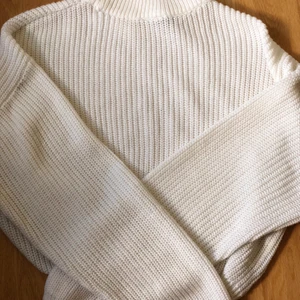 Croppad vit stickad tröja - Jättefin vit croppad tröja säljs för att den är för liten på mig. Tröjan är använd men bara några få gånger. Den är créme white och jätte mjuk. Tröjan är väldigt oversized i armarna men normal runt bysten.