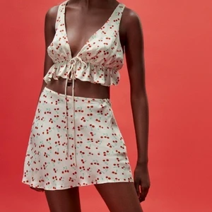 Kjol - Säljer denna söta kjol från zara med körsbär på! Materialet är i satin och har en dragkedja på sidan 💖 skriv för mer bilder 