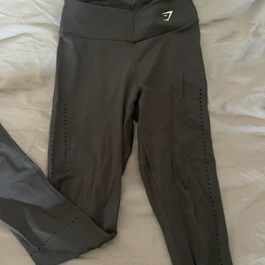 Gymshark tights - Jag säljer dessa svarta tights från gymshark, otroligt fint skick. Lite tunnare i materialet och är designad med hål på kanterna vid benen och ovanför rumpan. 