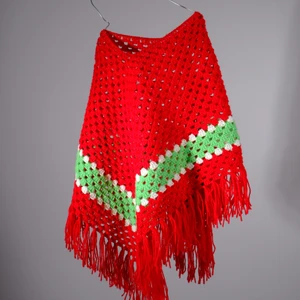 Stickad röd poncho  - One-of-a-kind stickad poncho i rött. Stickad av Röda Korsets-stickgrupp i Västerort tillsammans med Ebba Martin. Alla pengar från budgivningen går oavkortat till Röda Korsets arbete för att hjälpa människor i kris och katastrofer.