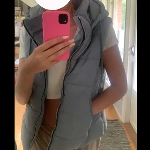 Vadderad väst med luva - Säljer denna skit snygga västen då ja aldrig använder den, använd ca 3 ggr, den är typ ljusblå/grå i färgen Nypris 400 Storlek M men passar S också