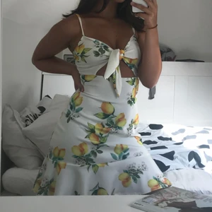 Klänning - Klänning med citroner i scuba material och knytning fram. Super mjukt o skönt material där man kan anpassa storleken vid brösten. Endast använd för bild. 