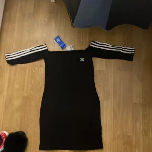 Adidas originals off shoulder dress black - Adidas klänning med off shoulders, slutar lite över knäna, i storlek 36 och färgen black noir.