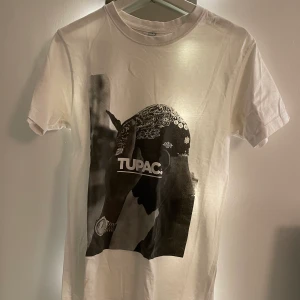 Tupac t-shirt - 💕Köpt från junkyard för kanske tre år sedan. Endas använd två gånger, skulle säga att skicket är väldigt bra. Tröjan har väldigt tjock kvalitet, vilket gör att den inte känns ”billig”. Har en ljusslinga i bak och därför lyser det lite om tröjan. 