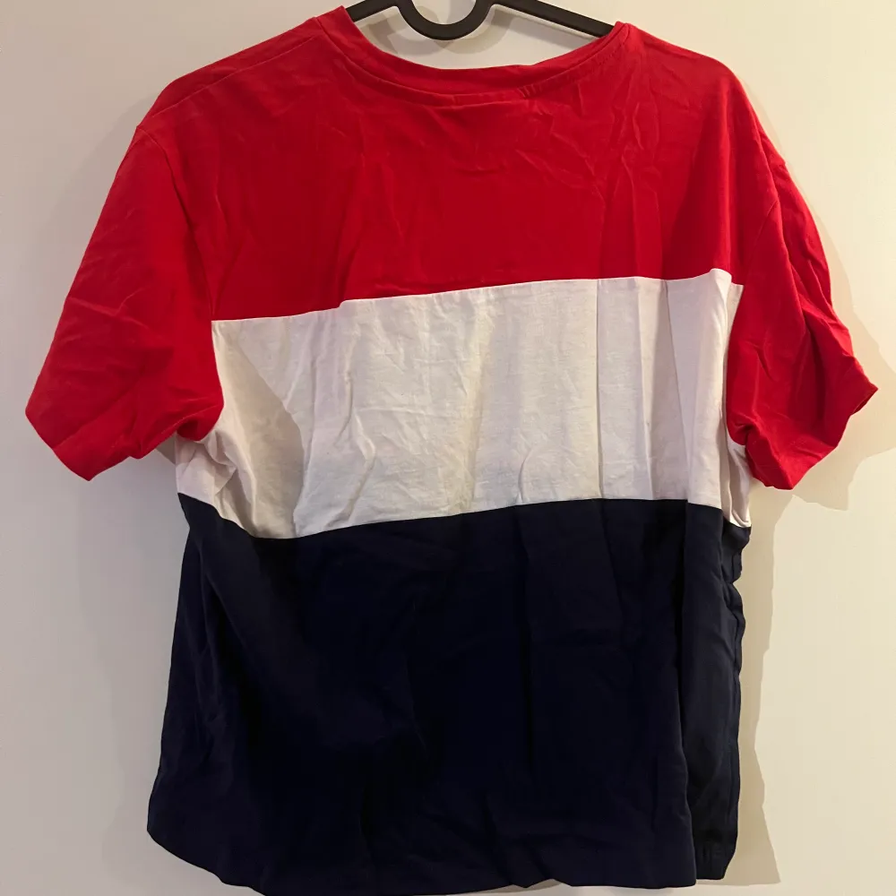 Randig T-shirt från fila, strecken är i rött, vitt och mörkblått. Fint skick.. T-shirts.