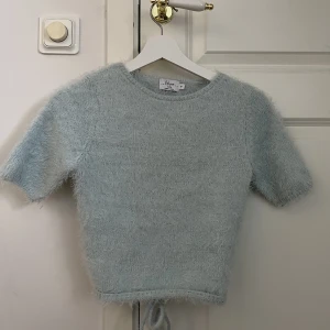 Ljusblå topp - Säljer min ljusblåa fluffiga topp från Hanna schönbergs kollektion med NA-KD. Den är endast använd en gång.