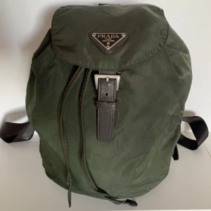 Prada vintage ryggsäck  - INKLUSIVE FRAKT❣️📦 Mörkgrön Vintage Prada Nylon ryggsäck. Medelstorlek. Unisex.  ❣️Skickad PM för fler bilder eller vid frågor.  ❣️Defekter: små defekter på den övre delen av väskan.  Se bilder.  allmänt slitage som kan förväntas för en 10+ år gammal väska.