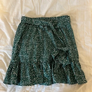 Grön vitprickig kjol (Shein) - Grön kjol med vita prickar och knytdetalj  från shein,använt några fåtal gånger,stl XS