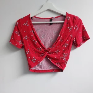 Topp - Röd topp med blommönster köpt från H&M i stl.XS, kan passa en S.