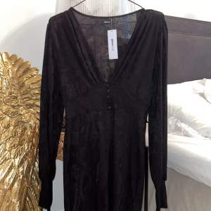 Helt ny svart elegant midi klänning från Gina Tricot, fint mönster med knappar framtill, ”puffärmar” som blir tajta längt ned vid ärmslut  Strl M  Nypris 459kr 