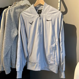 Nike rafa court jacket - Nike rafa court jacket i storlek S sparsamt använd med endast en väldigt liten fläck vid vänstra ficka, annars bra skick. Kontakta om du har frågor eller vill ha fler bilder.