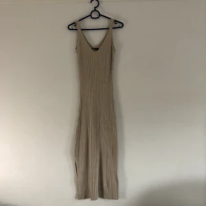Beige ribbad midiklänning  - Midiklänning från Ginatricot  Storlek L men omsydd till att passa någon mellan S-M Stretchigt tyg  Använd ett fåtal gånger, bra skick 