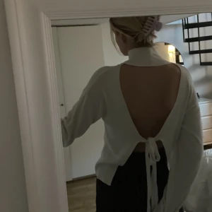 Hanna schönberg x NAKD  - Så fin vit stickad polo med öppen rygg och knyt.