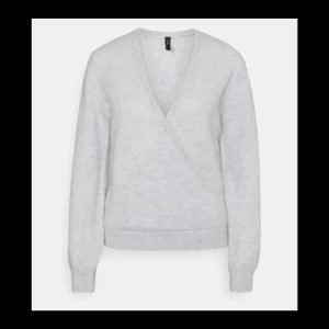 Yas  - Stickad tröja i wrapmodell. Kortare modell. Struktur i tyget vid ärmslutet och framsidan.