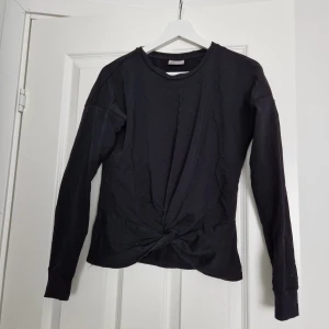 Svart topp - En svart topp med en knut på framsidan. Använd några gånger.  Obs! Frakten ingår i priset 