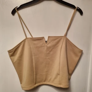 Beige korset top från bikbok - Fin topp i beige. Säljer då fel storlek för mig. Gåva från familjemedlem, använt få gånger. 