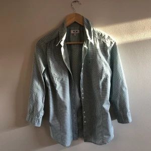 Skjorta, grönrutig - Skjorta med inslag av grön, ljusblå och vit. Bomull. Med tillhörande knappar.