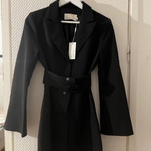 NY kostymklänning från nelly - Aldrig använd!!!! Lapp sitter kvar, avtagbart skärp i midjan om man vill. Den e lite stor i storleken tycker jag