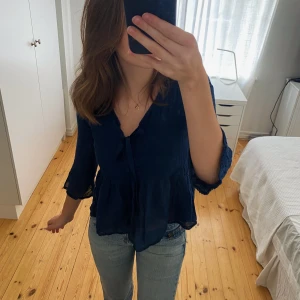 Blå blus - Säljer denna söta blå blus med rosett framtill. Storlek XS men passar även S. Skriv för fler bilder! Köp direkt för 200kr