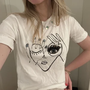 Tröja med coolt motiv  - Denna coola och unika tröja hittar man inte överallt, den har små stenar o ögonfransarna som sticker ut från tröjan. I strl 36❤️