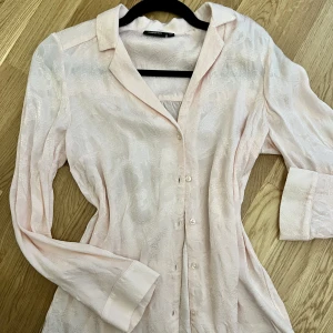 Ljusrosa blus - Snygg och silkig blus med detaljer (2 bild), passar S/M. Säljer pga det inte kommer till användning. 