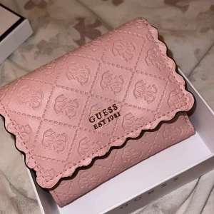 Guess plånbok - En present som aldrig blev använd, jättegullig plånbok med rosa och guld design. Plats för mynt, sedlar samt kort.