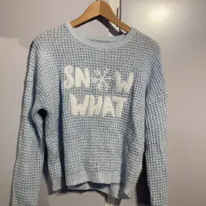 En blå stickad tröja från New Yorker med texten ”Snow What”. Tröjan är i storlek medium och använd ett fåtal gånger. Mjukt material och sticks inte! :)