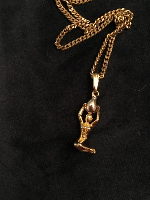 Halsband kvinna  - Gyllene kvinna som håller silverfärgad boll. Okänt material.