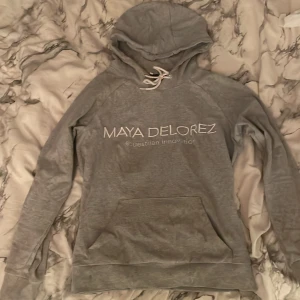 Maya Delorez hoodie  - Grå maya delorez hoodie med svart streck på ryggen. Sitter mer som en M men är väldigt Stretchig och jätte skön. Nypris 1000kr nu 250kr