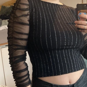 Vintage glittertopp - En topp jag hittade på vintageaffär i Malmö, jätte fint skick, jag har aldrig använt den står ingen storlek men jag är en S-M. Glittret sitter fint på tröjan och verkar inte lossna. Slutar precis ovanför naveln, jag är 169 cm lång. 
