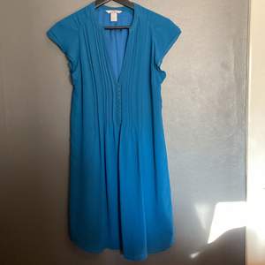 En blå klänning från H&M. Knappar fram. Sparsamt använd