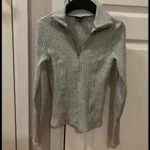 En grå zip tröja (dragkedja) från Gina Tricot i stl XS. Bild 2 och 3 är hur plagget ser ut på men i en blå färg