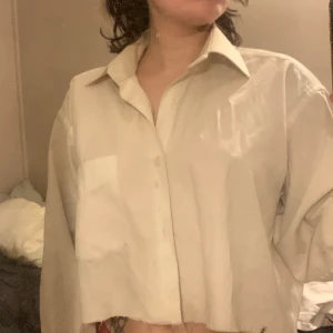 Croppad skjorta  - Croppad skjorta med en ficka. Lite längre i ärmarna!